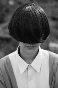 woman with cropped hair covering her face