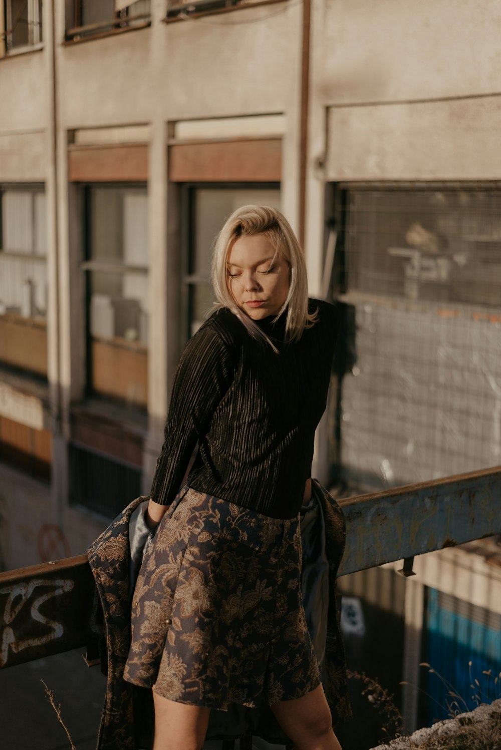 woman wearing black long-sleeved shirt and gray floral flare skirt