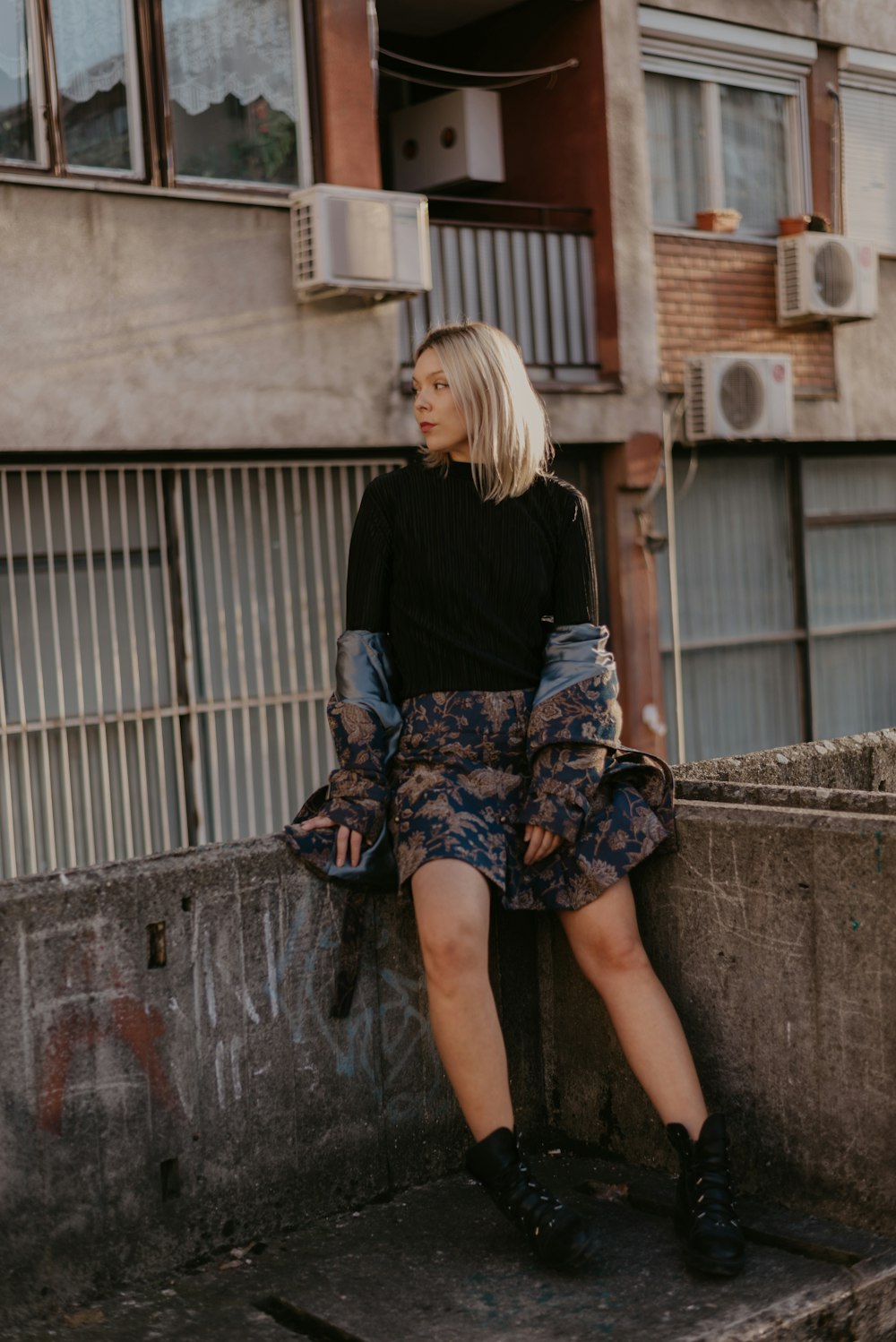 Femme assise sur des balustrades en béton sur le toit