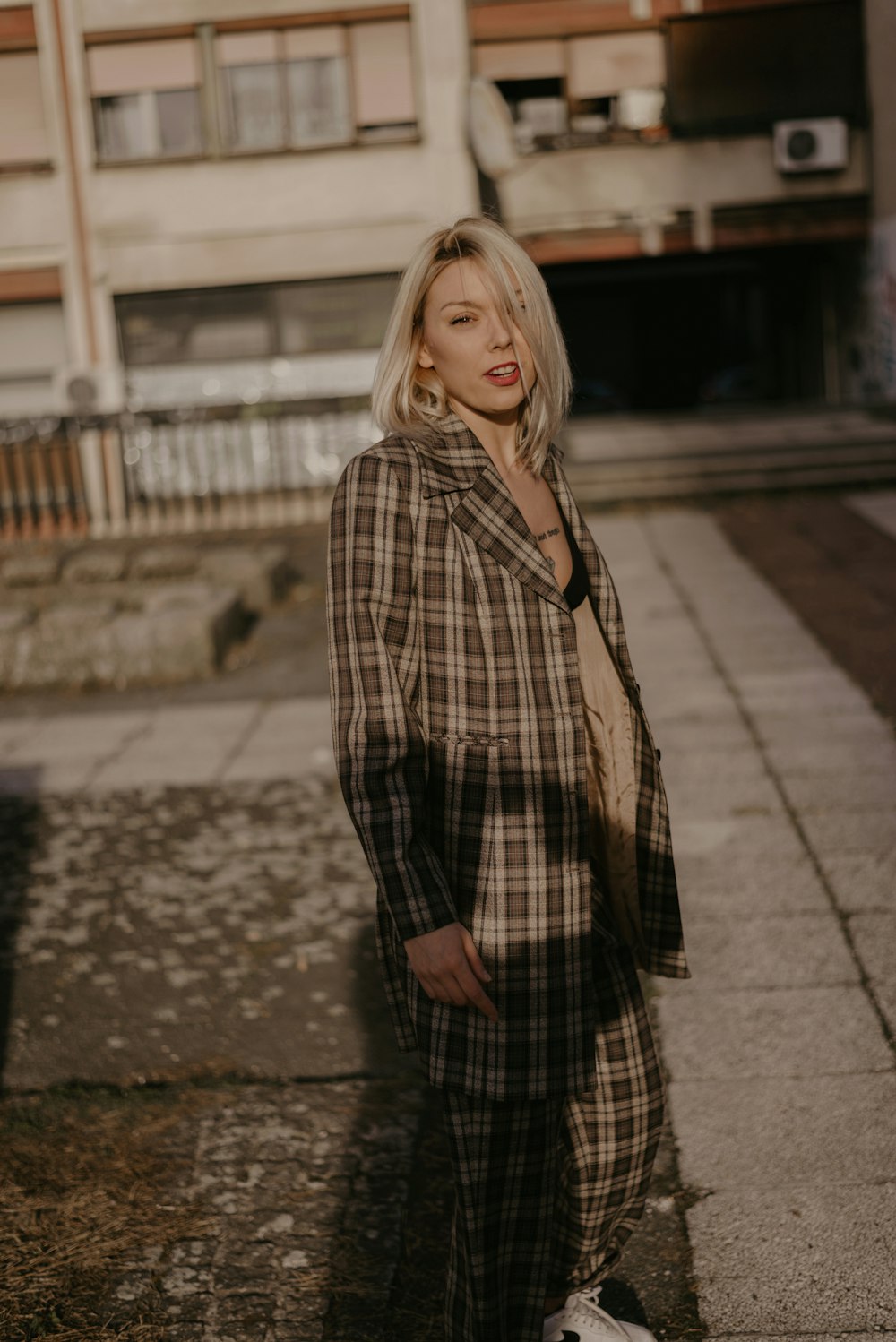 woman wearing brown and white plaid coat during daytime