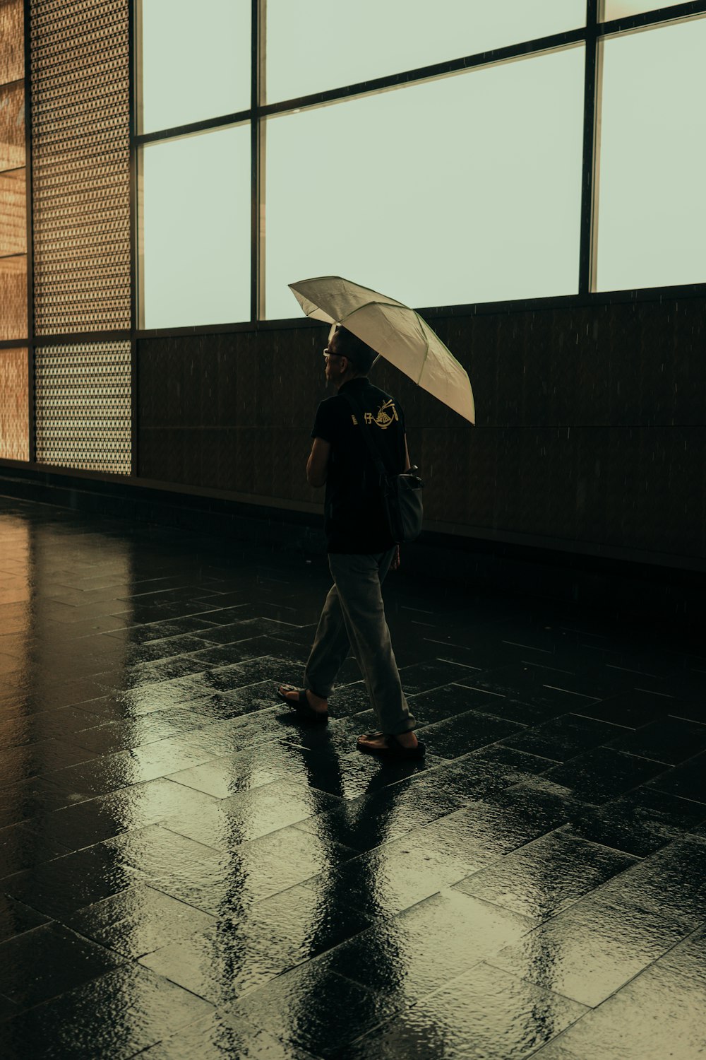 傘をさしながら歩く男