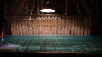 A close-up of hands weaving digital threads glowing softly against a dark background.