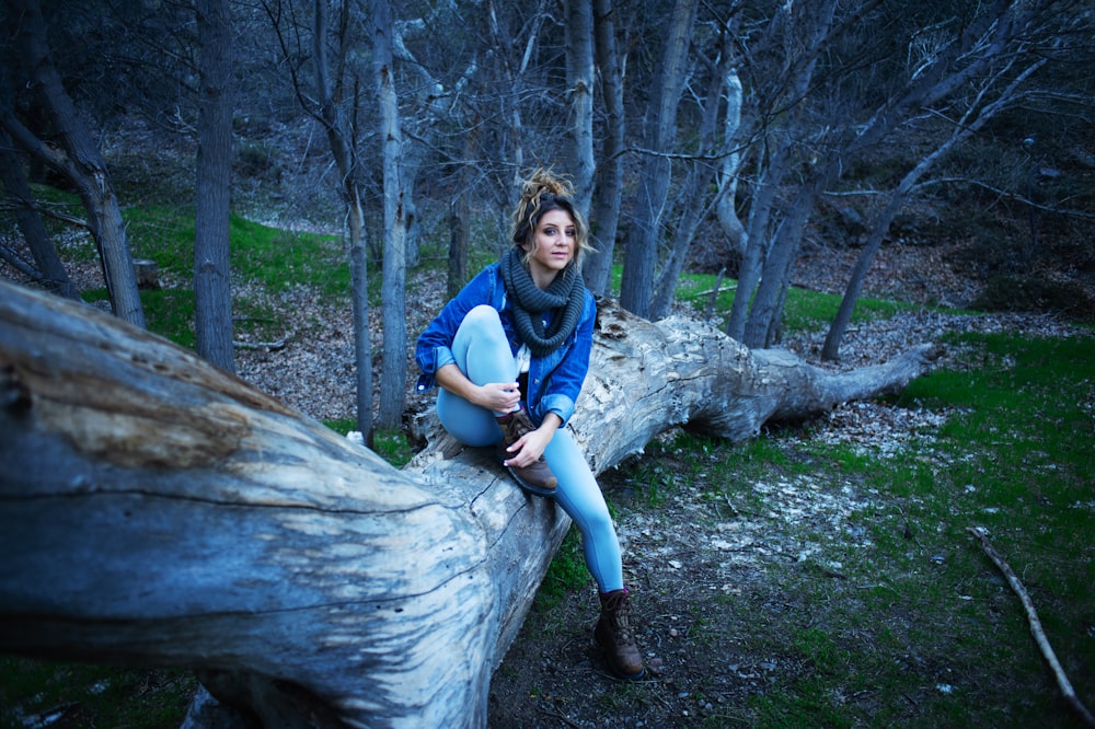 woman sitting on wood log