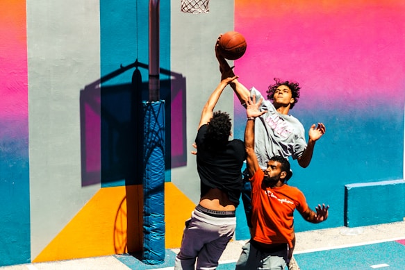 three people playing basketball