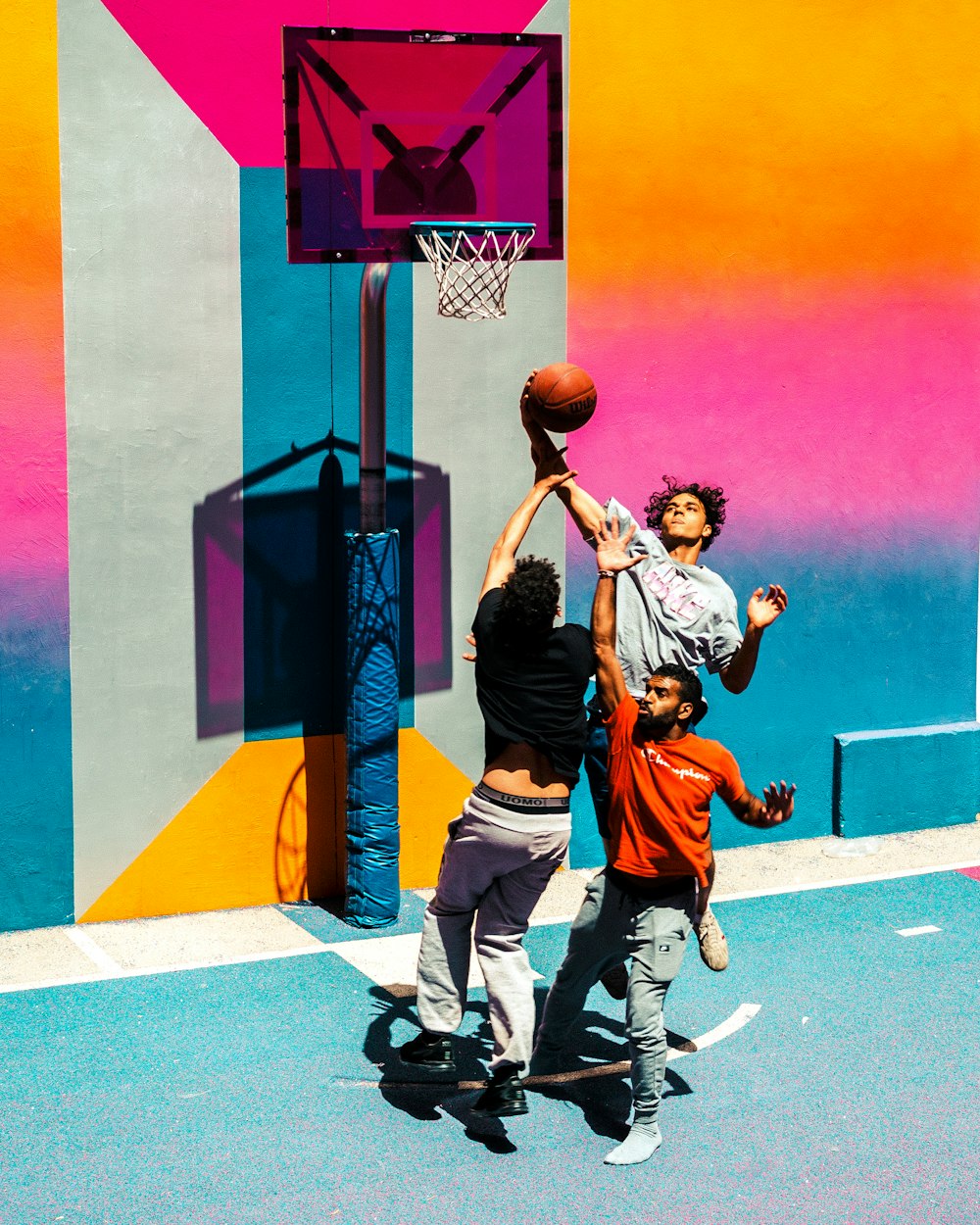 three people playing basketball