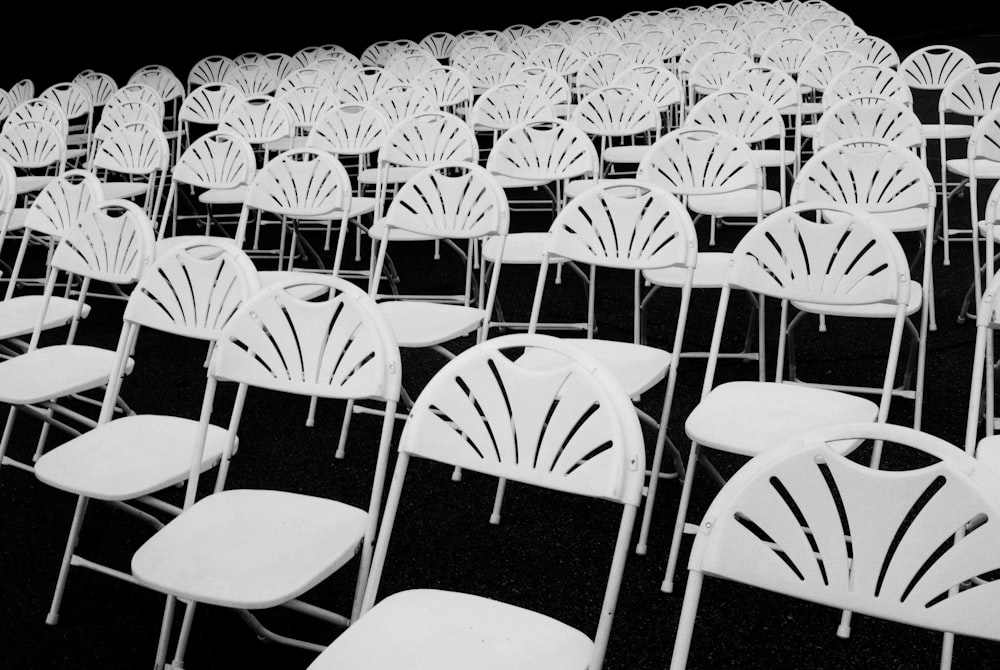 pile of white metal folding chairs