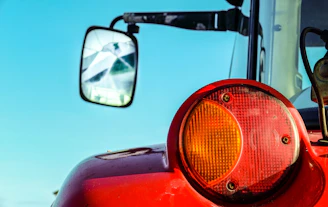 Close-up of a shiny adjustable top link attached to a tractor implement under bright daylight