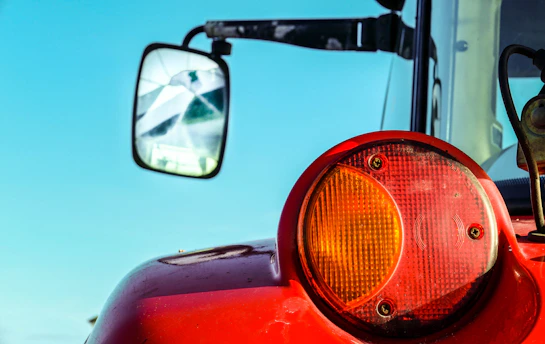 Close-up of a shiny adjustable top link attached to a tractor implement under bright daylight