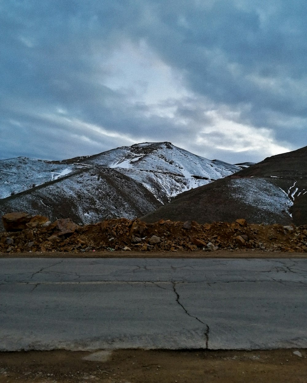 snow covered mountain under cloudy sky during daytime