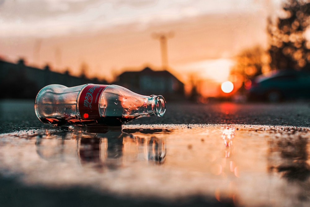 Botella de Coca-Cola sobre pavimento gris