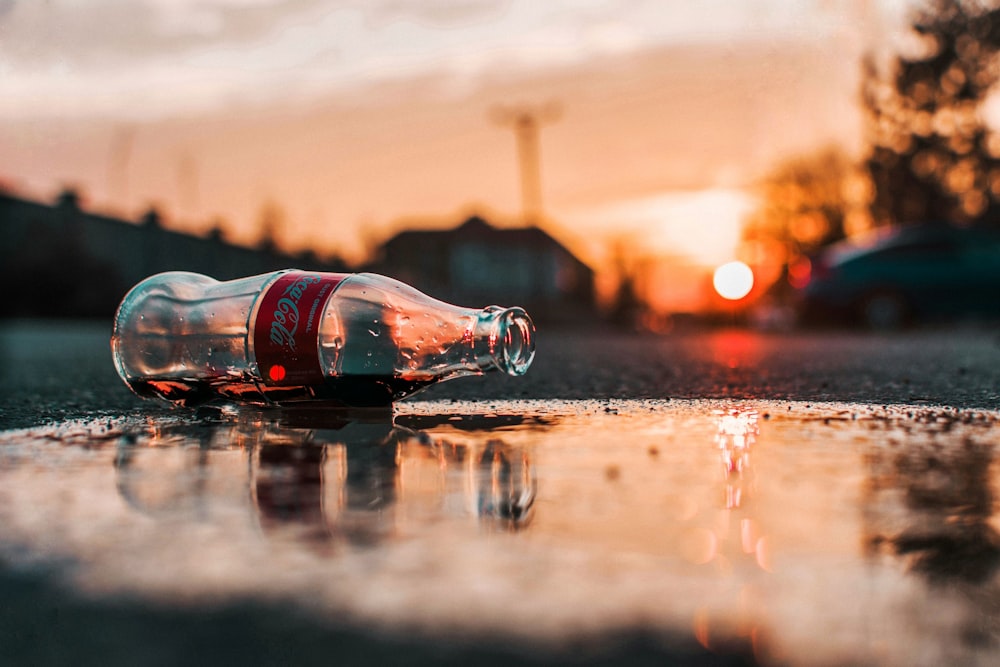 coca-cola bottle on grey pavement