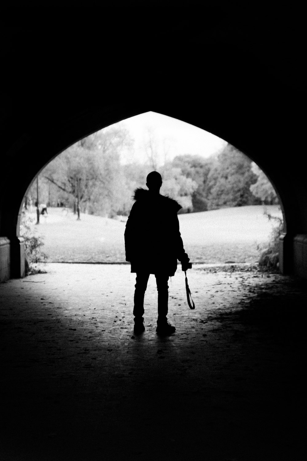 person standing inside tunnel