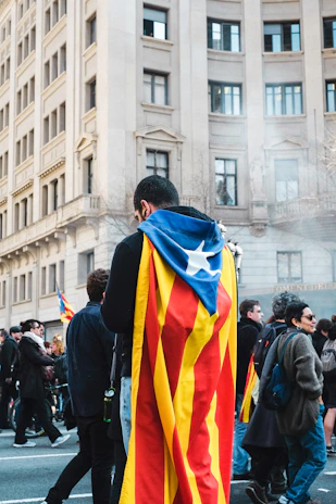 Modern portrait of a veteran in uniform, standing proudly with the Catalonia flag.