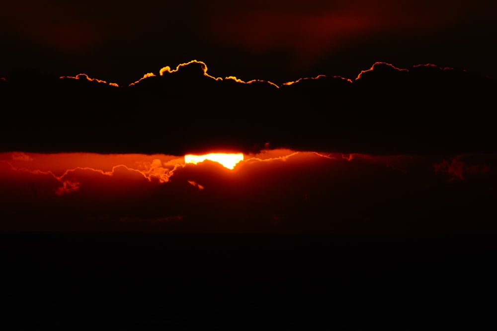 silhouette photography of sun behind clouds during golden hour