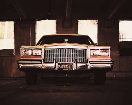 A vintage car parked beside a friendly DMV service counter with paperwork and title documents.