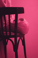 Artistic shot of a t-shirt draped over a chair, with colorful paint splatters in the background to echo the shirt’s design.
