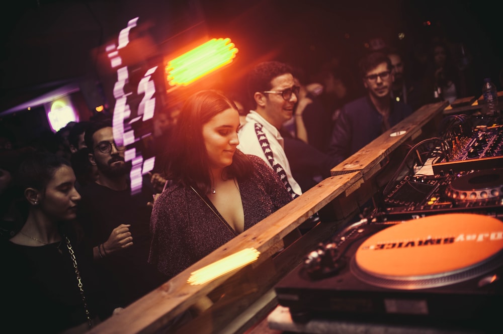 group of people standing in front of DJ controller