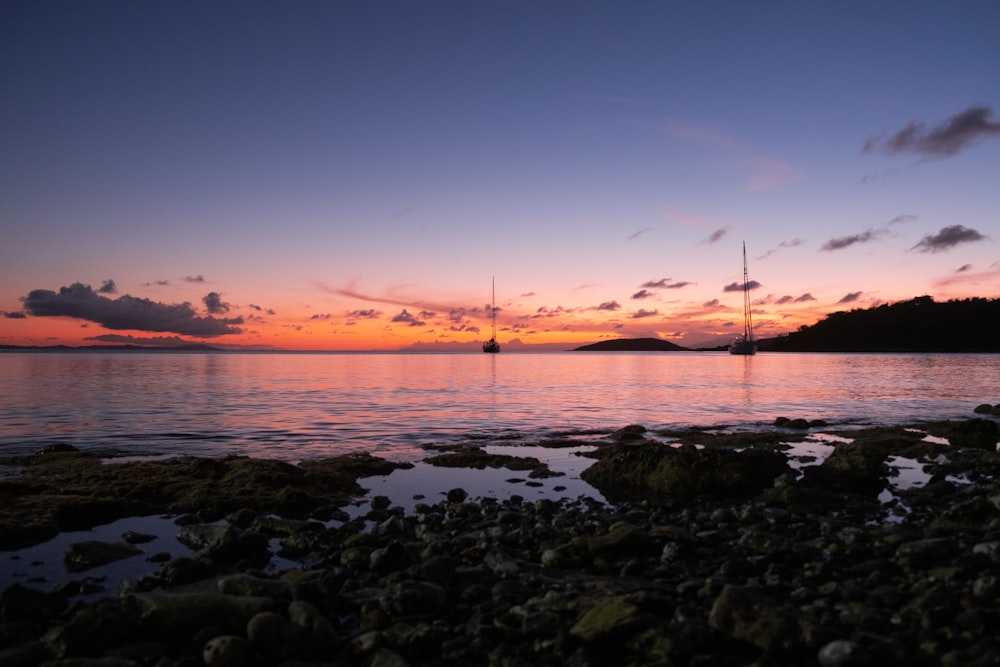 low-angle photography of rocks and body of water