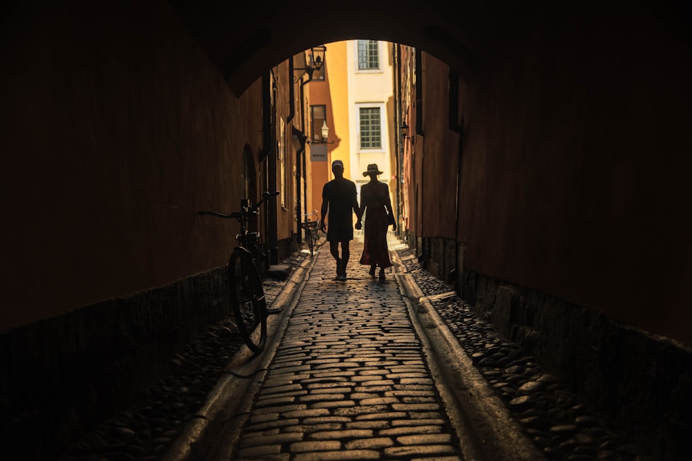 two person walking on tunnel