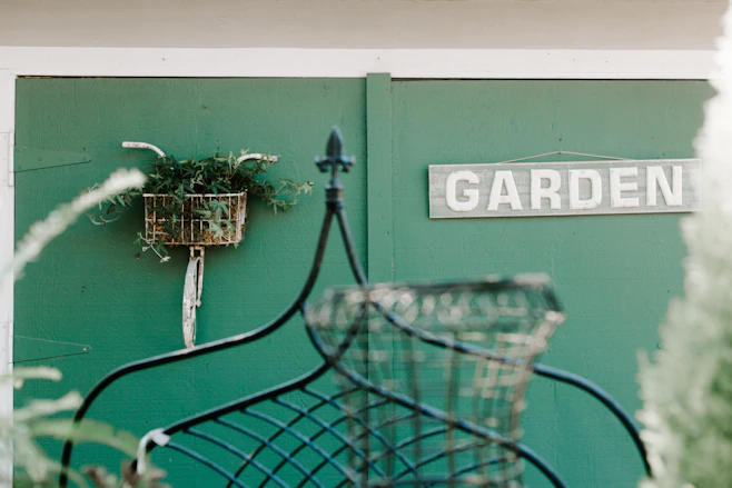 A cozy home garden with fresh green plants and a wooden sign that says 'verdeviva'.