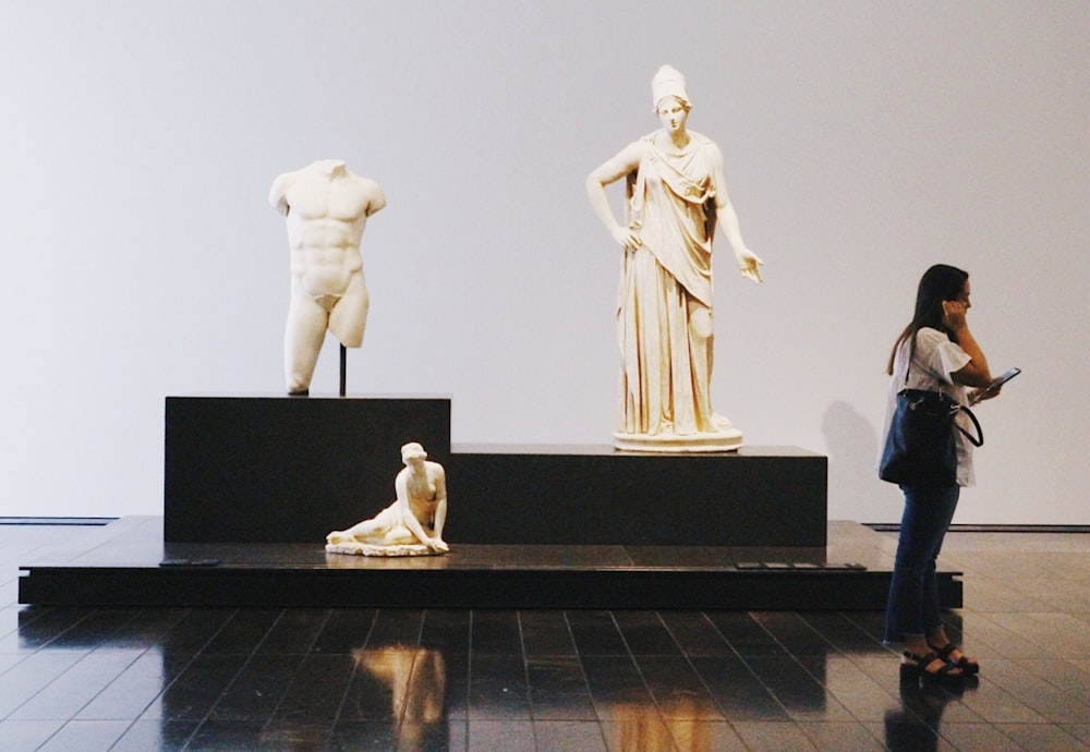 Mujer de pie sobre la mujer con la estatua del vestido blanco