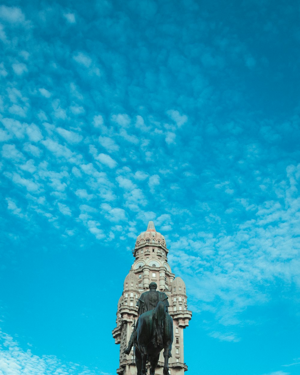 uma estátua de um homem em um cavalo na frente de um edifício