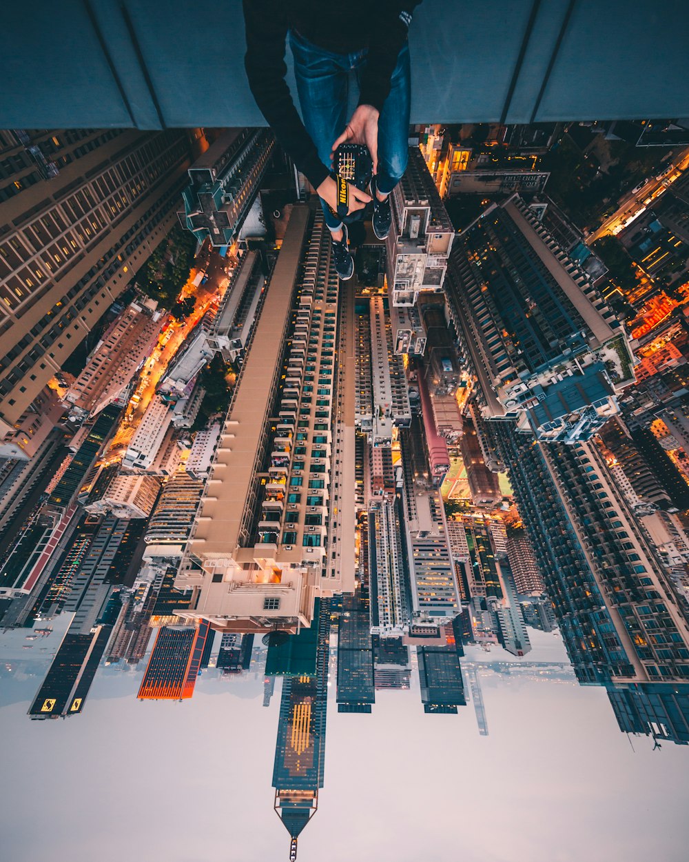 man sitting on top of building facing high-rise buildings