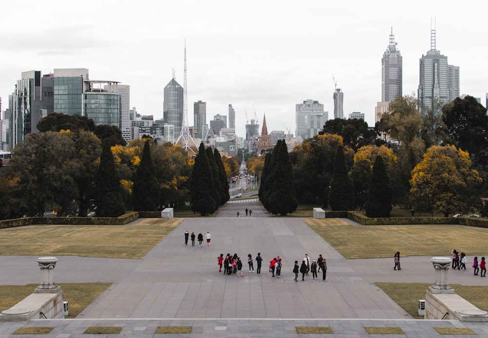 in distant photo of group of people standing on concrete pavement