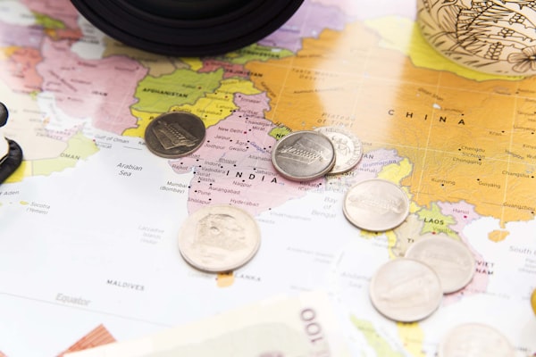 Coins resting on a world map representing travel spending decisions