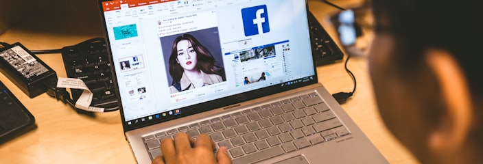 person using laptop browsing facebook application