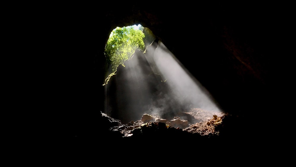 a light coming from a cave into a body of water