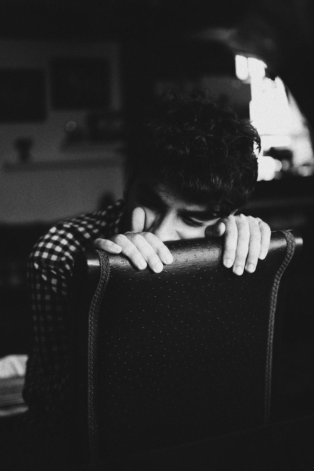 grayscale photography of person sitting on chair