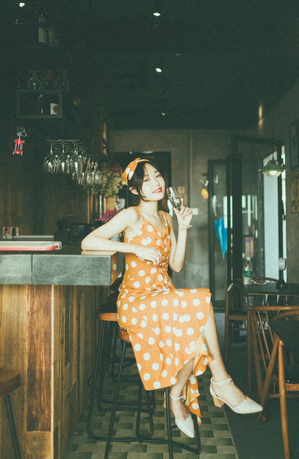 woman sitting on round brown stool leaning on table