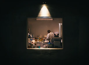 An artisan carefully blending rare ingredients in a softly lit, elegant workshop.