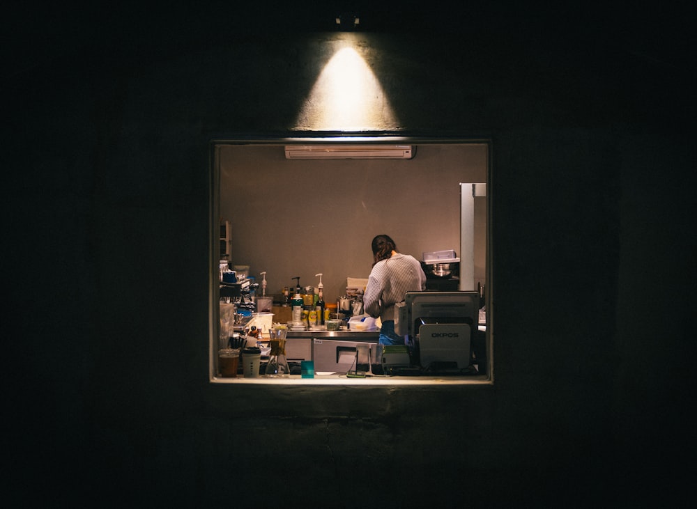 foto de pouca luz da mulher em pé na área da cozinha