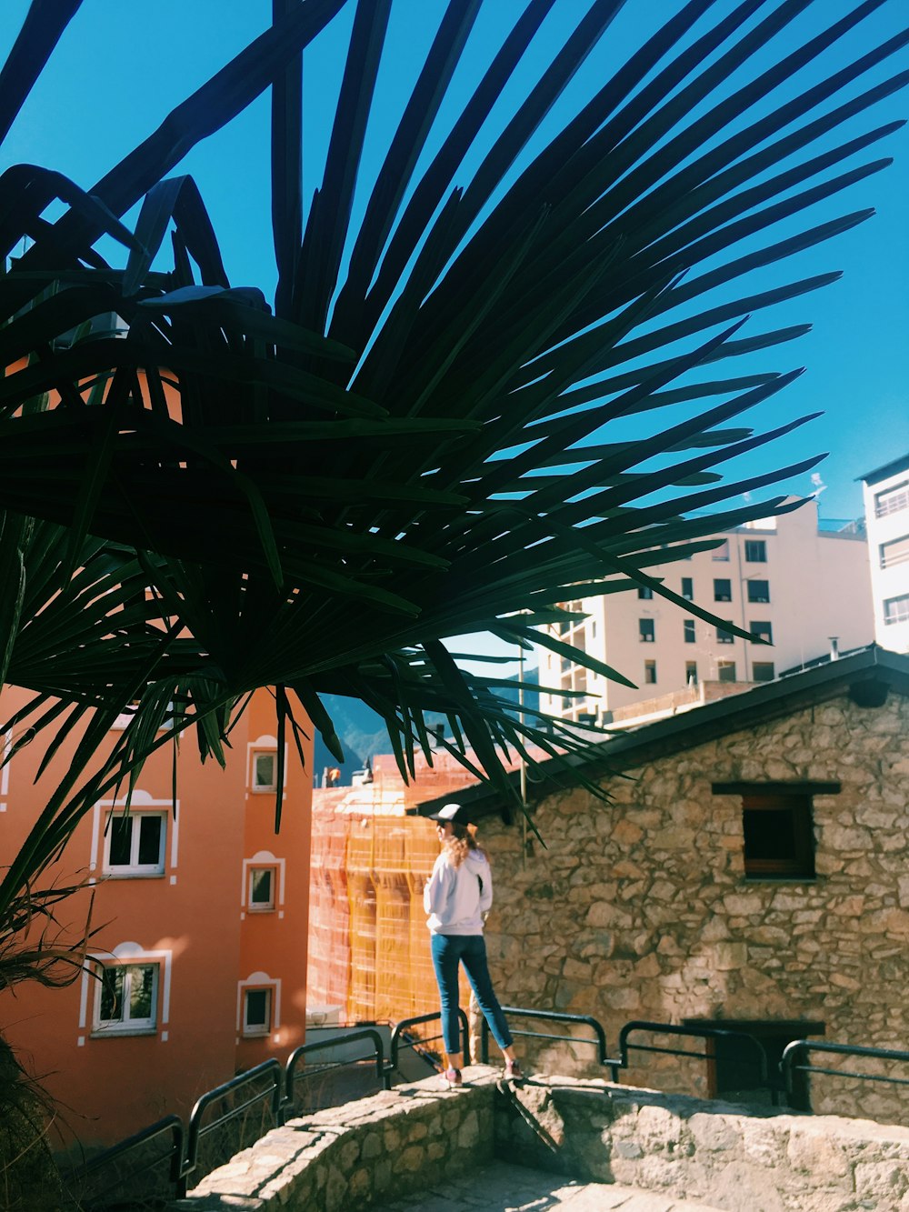 person standing on stone rail near buildings