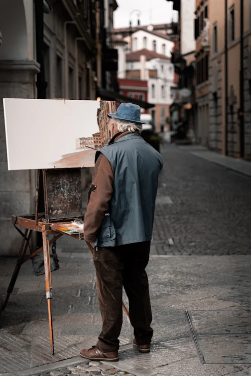 Jeune artiste fier devant son chevalet à l'atelier de peinture
