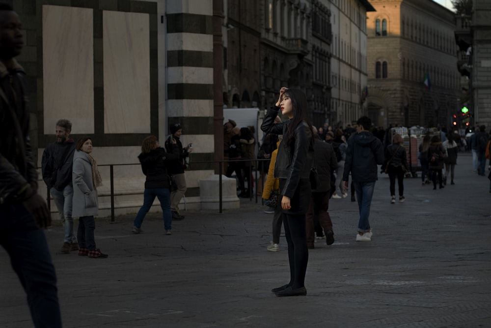 person in black top standing beside road