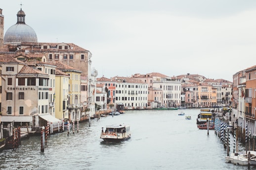 white passenger boat on river between houses