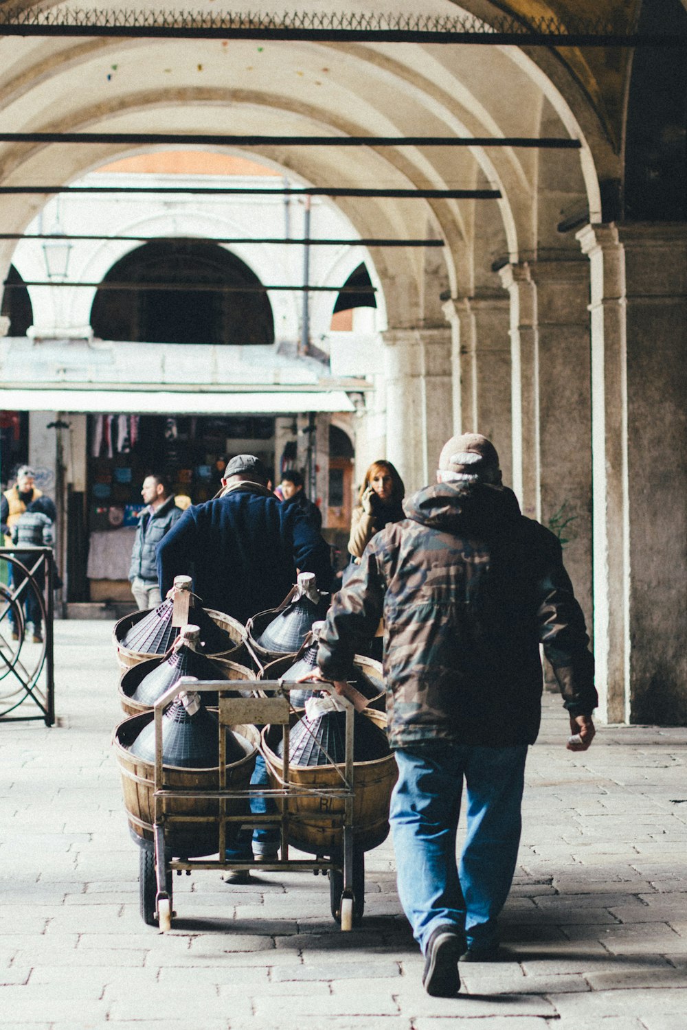 people walking and pushing cart