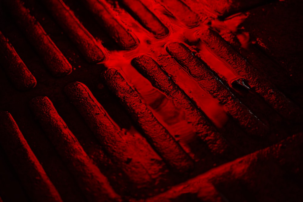 a close up of a grate with a red light