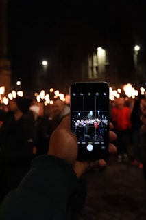 A concerned citizen holding a smartphone, capturing a street protest in San Miguel de Allende at sunset.