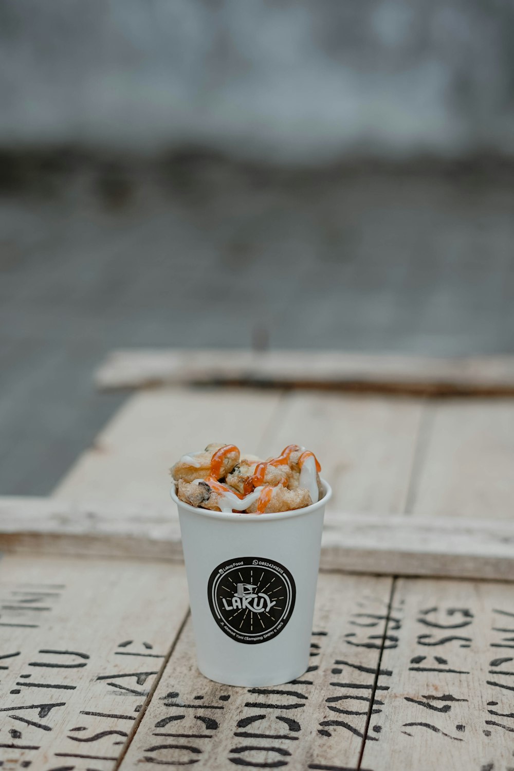 filled white and black disposable cup on brown wooden surface