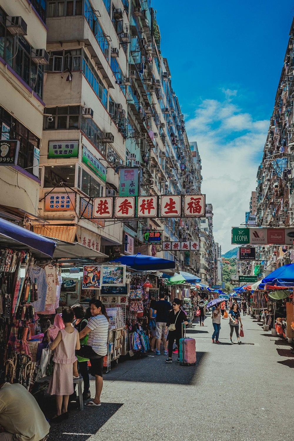 people walking and standing at the outdoor market of the city