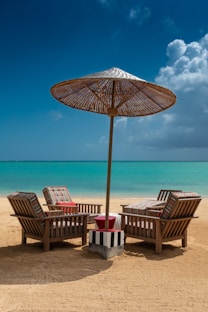 brown wooden 5-piece patio set on sand during daytime