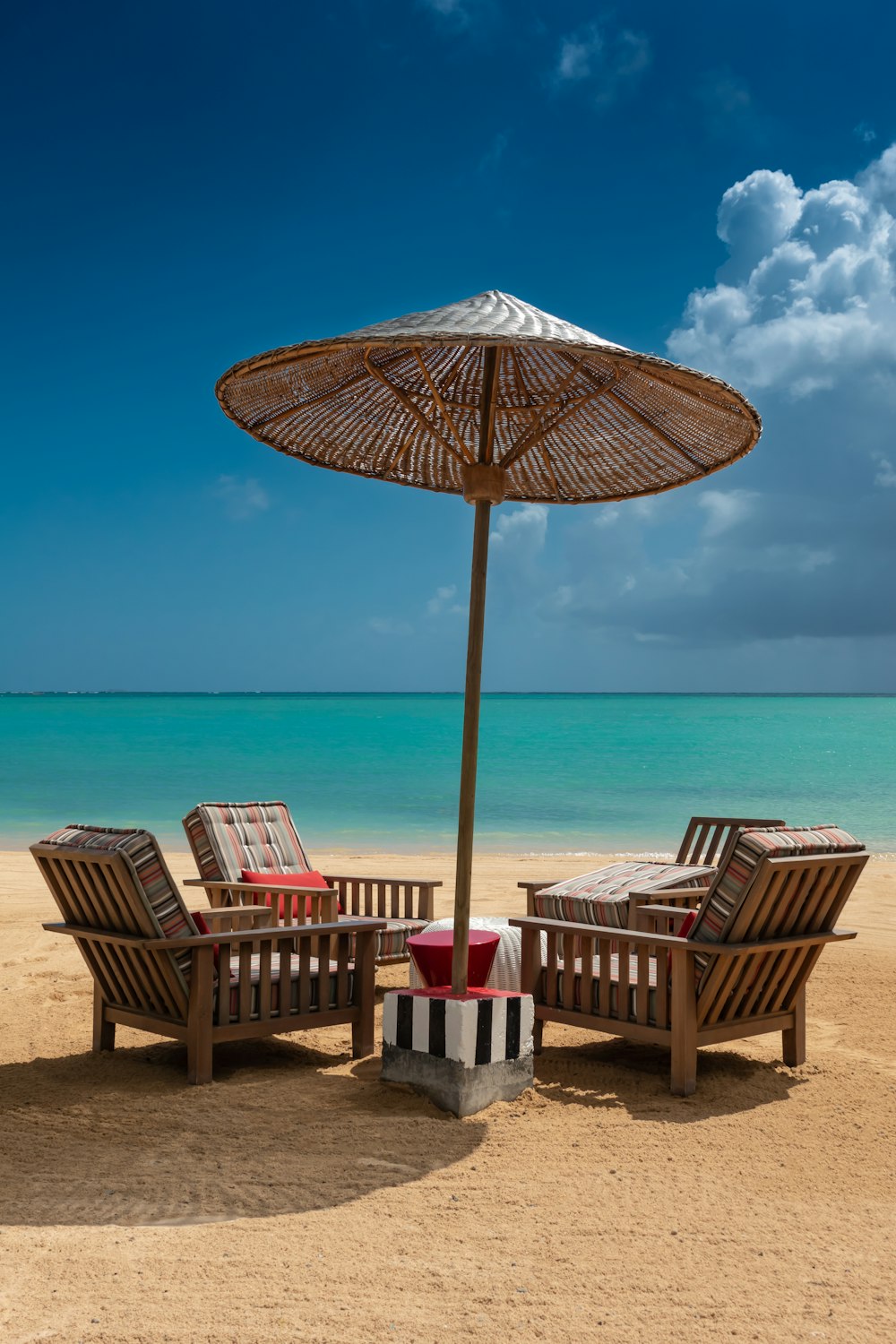 brown wooden 5-piece patio set on sand during daytime