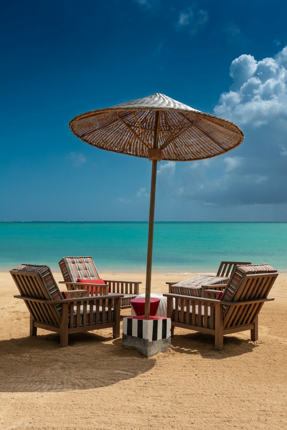 Ensemble de patio en bois brun de 5 pièces sur le sable pendant la journée