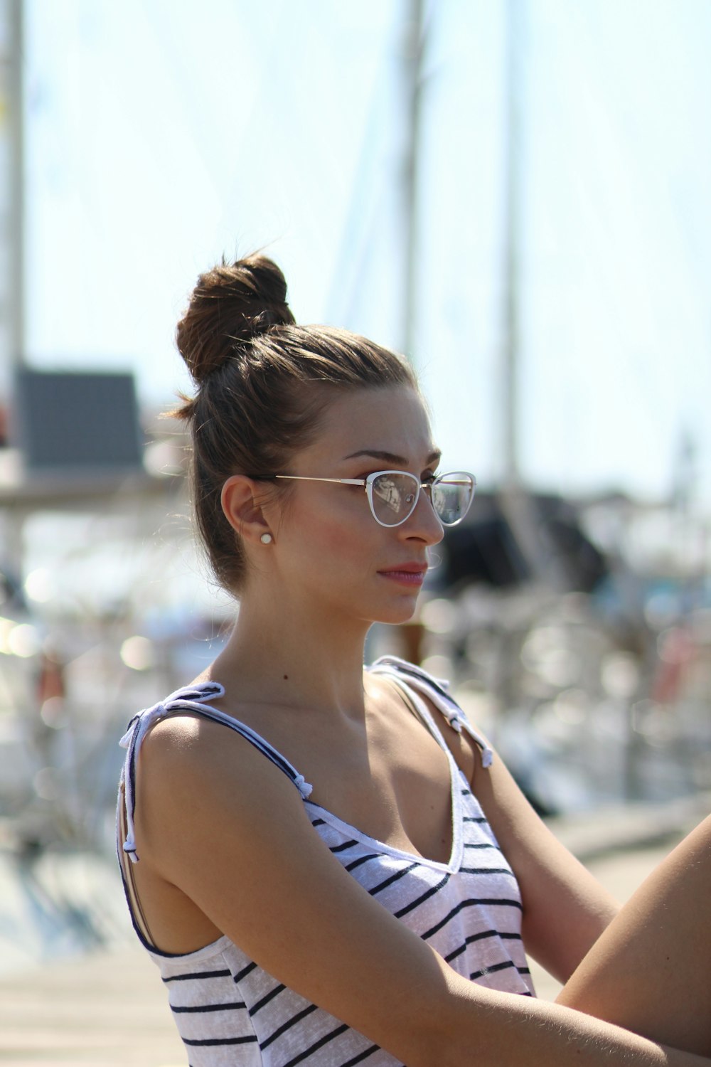 woman wearing grey framed eyeglasses and white and black striped top