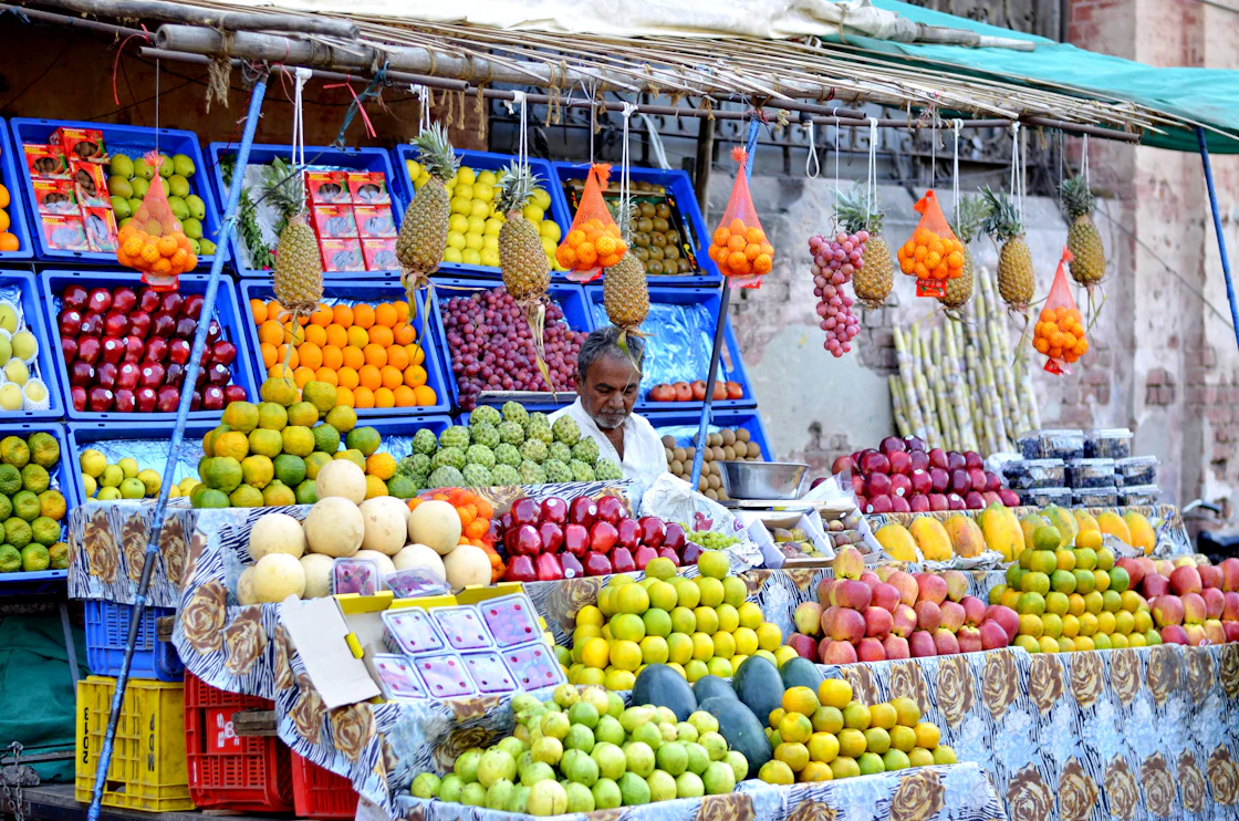 A market stall displays a variety of fruit in daylight