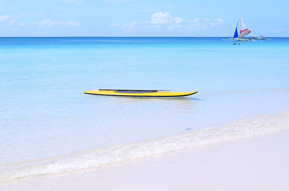 yellow kayak on ocean during daytime